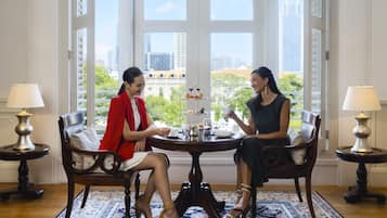 Dos personas sentadas en una mesa redonda con vistas a un paisaje urbano a través de amplios ventanales.