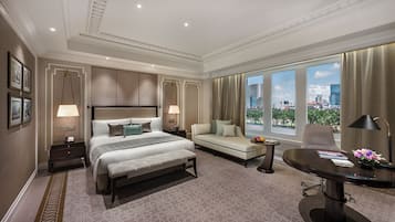 Habitación de hotel con una cama grande, un sofá, un escritorio y vistas a la ciudad.