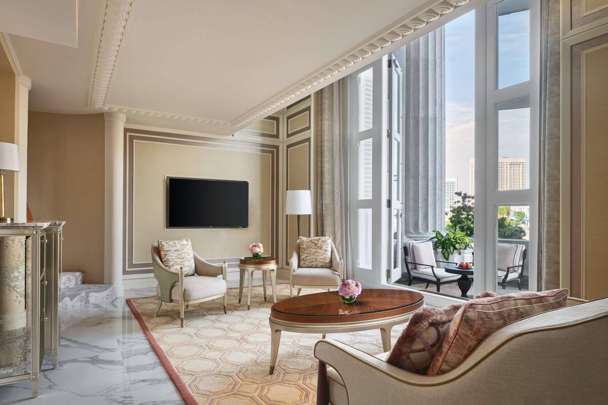 A spacious living room with a large window, a flat-screen TV, and a comfortable seating area.
