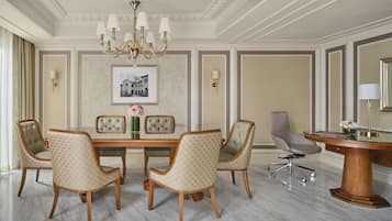 Un comedor formal con piso de mármol, una mesa de comedor de madera y seis sillas tapizadas.