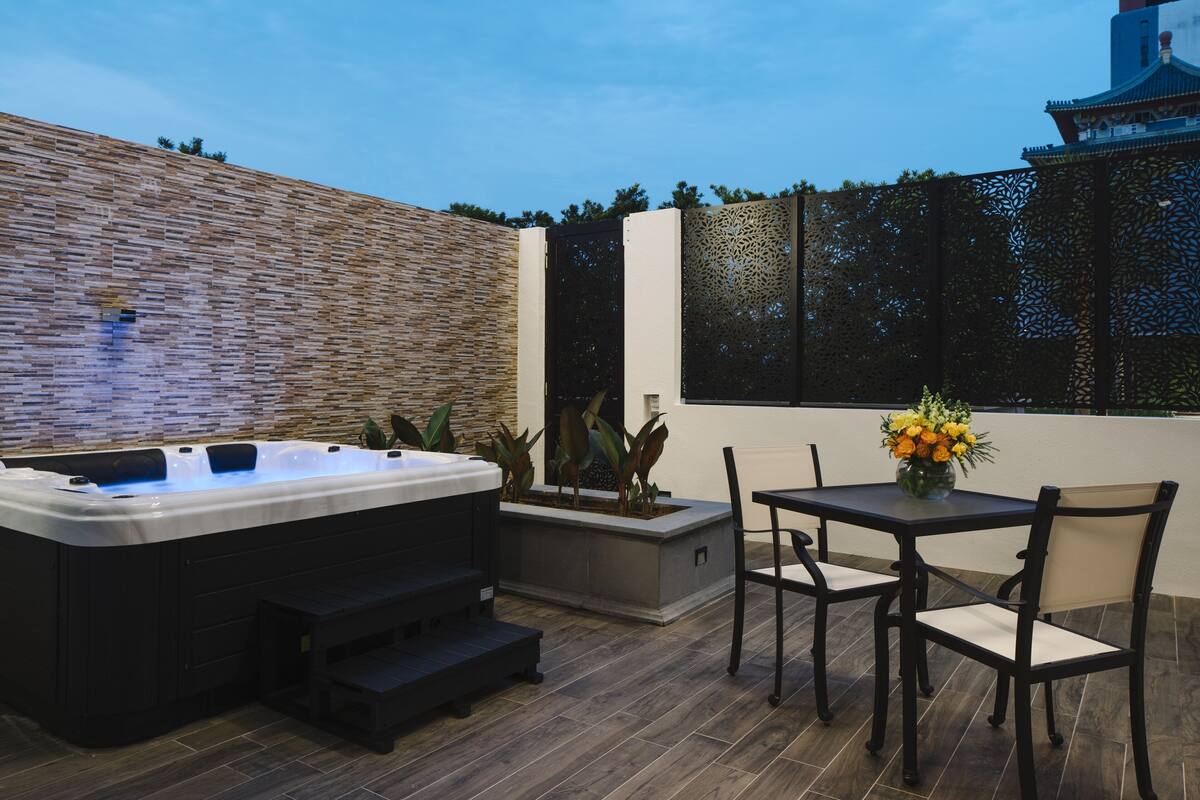 A hot tub, outdoor seating, and a view of a traditional building.