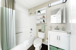 Kombinasi shower/bathtub, handuk, sabun, dan tisu toilet