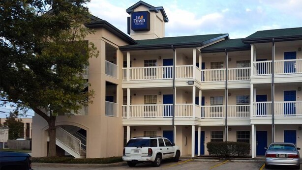 A multi-story motel with balconies and a central staircase. - InTown Suites Extended Stay New Orleans - Metairie (Metairie)