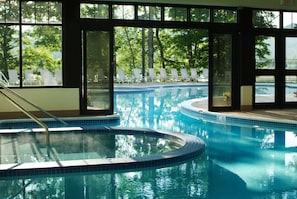 Una piscina de diseño curvo, rodeada de amplios ventanales iluminados por luz natural.