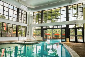 Una amplia piscina interior con varias pistas de natación, rodeada de grandes ventanales que ofrecen vistas al exterior.