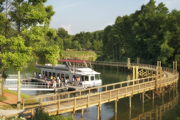 Un bateau fluvial était amarré à un quai en bois, et les passagers montaient et descendaient à bord.