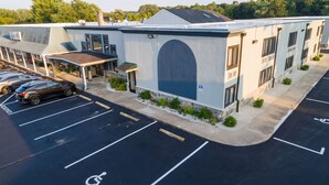 A building with a parking lot, a covered entrance, and a sign for 'Walt A. Souffle'.