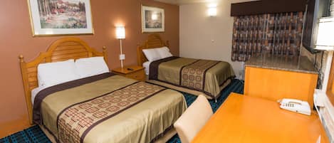 Habitación de hotel con dos camas, un escritorio, un teléfono y dos lámparas de pared.