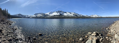A clear lake with rocky shores and a mountain in the background.