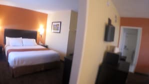 A hotel room with a bed, bedside table, lamp, and a framed picture on the wall. - Americas Best Value Inn Blythe (Blythe)