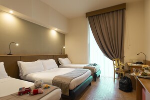 Een hotelkamer met twee bedden, een bureau, een stoel en een eettafel met een maaltijd erop.