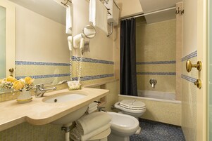 Un baño con lavamanos, espejo, secador de pelo y bañera.