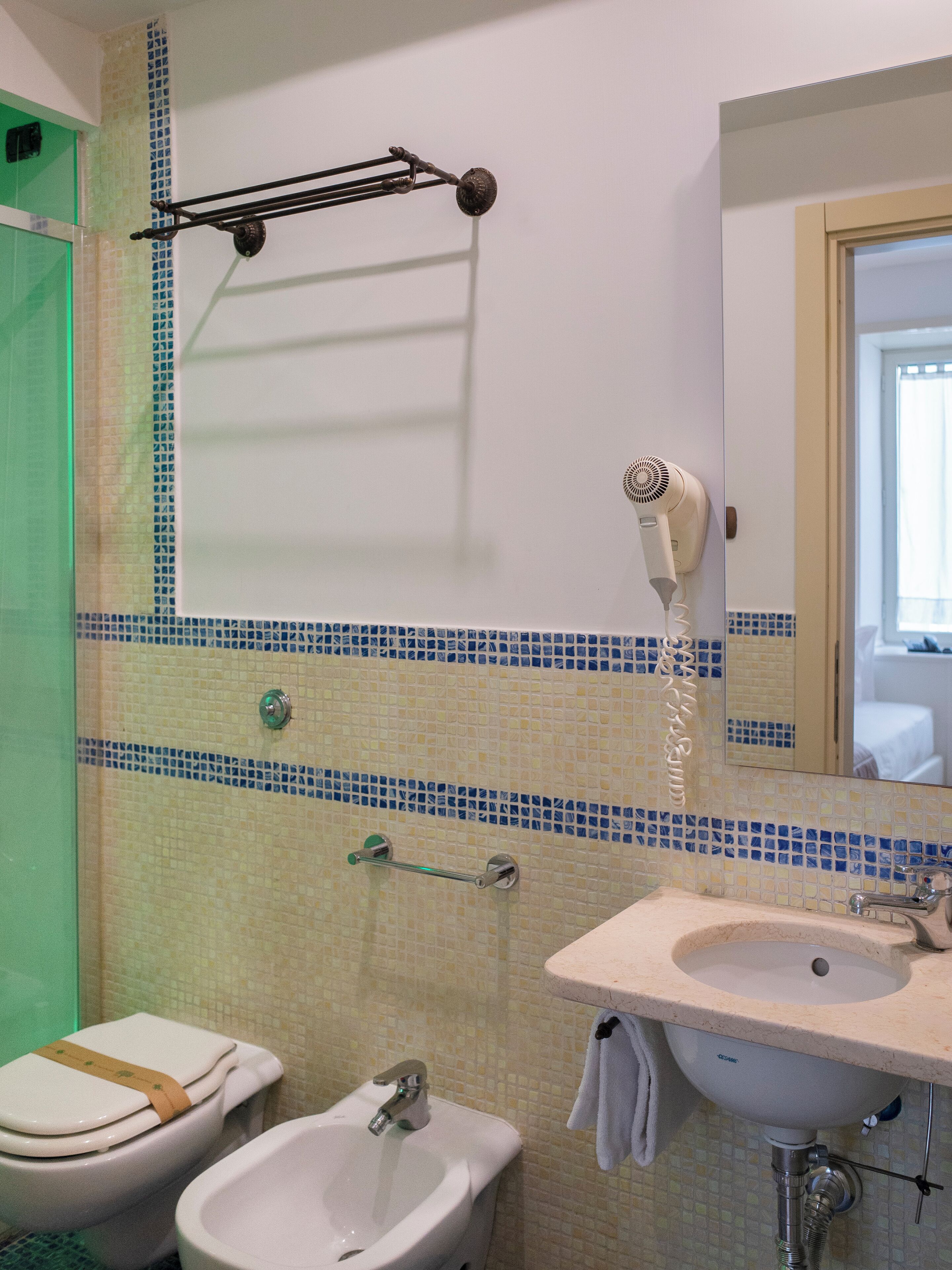 A bathroom with a toilet, bidet, and sink.
