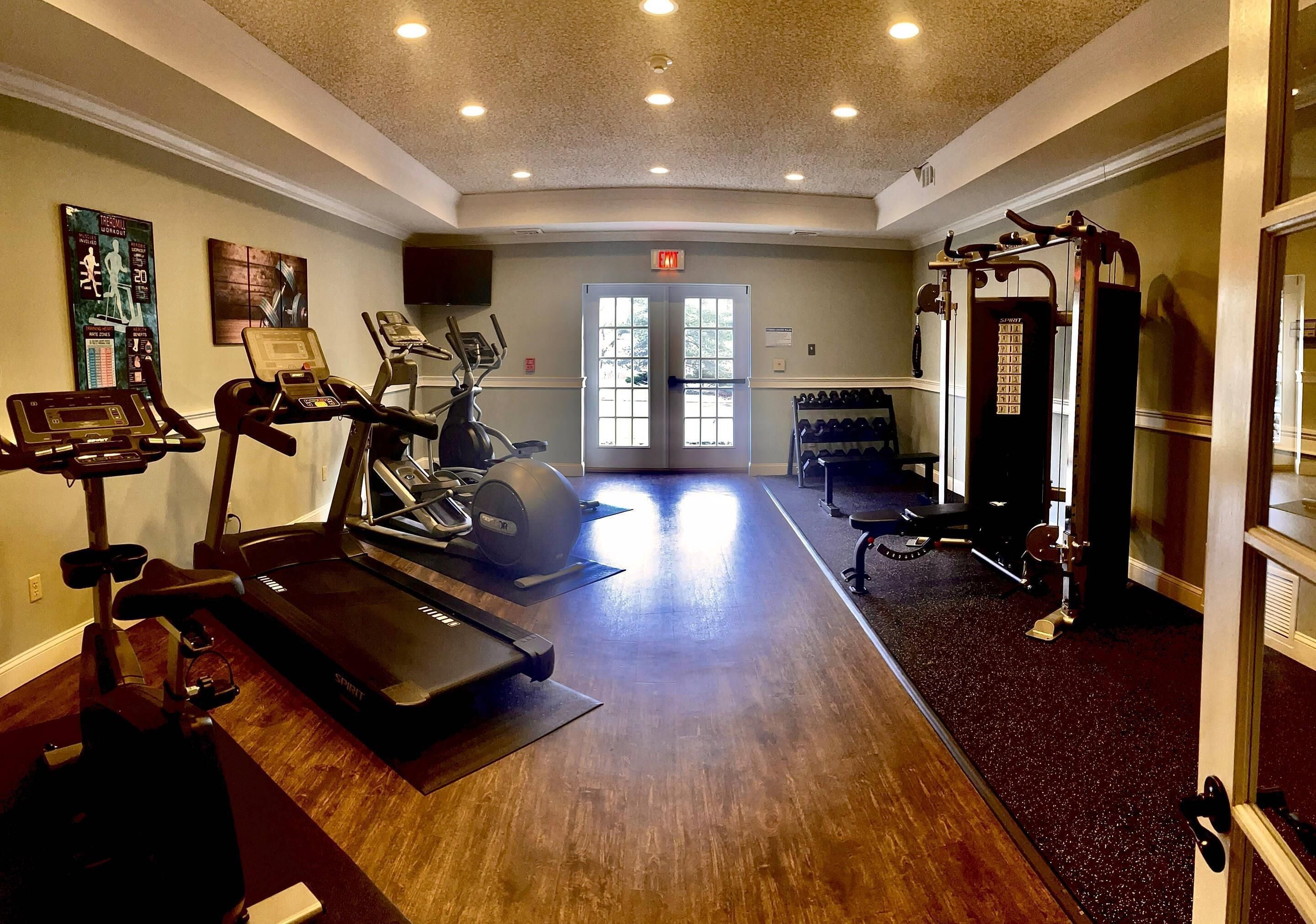 A gym with treadmills, stationary bikes, and weight machines.