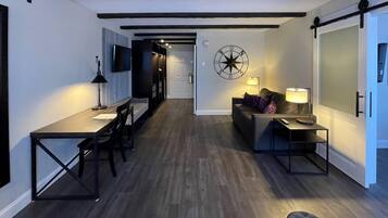 A modern interior with a dining area, a sofa, and a wall-mounted clock.