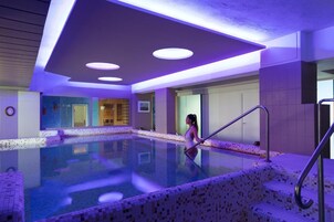 Una piscina techada, una piscina al aire libre de temporada, sombrillas