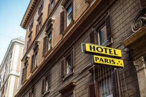 Une enseigne d’hôtel portant l’inscription « HÔTEL PARIS » sur la façade d’un immeuble.
