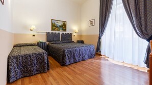 A bedroom with two beds, wooden flooring, and a large window with curtains. - Hotel Paris (Rome)