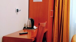A room with a wooden desk, a chair, a television mounted on the wall, and a window with curtains. - Hotel Everest (Rome)