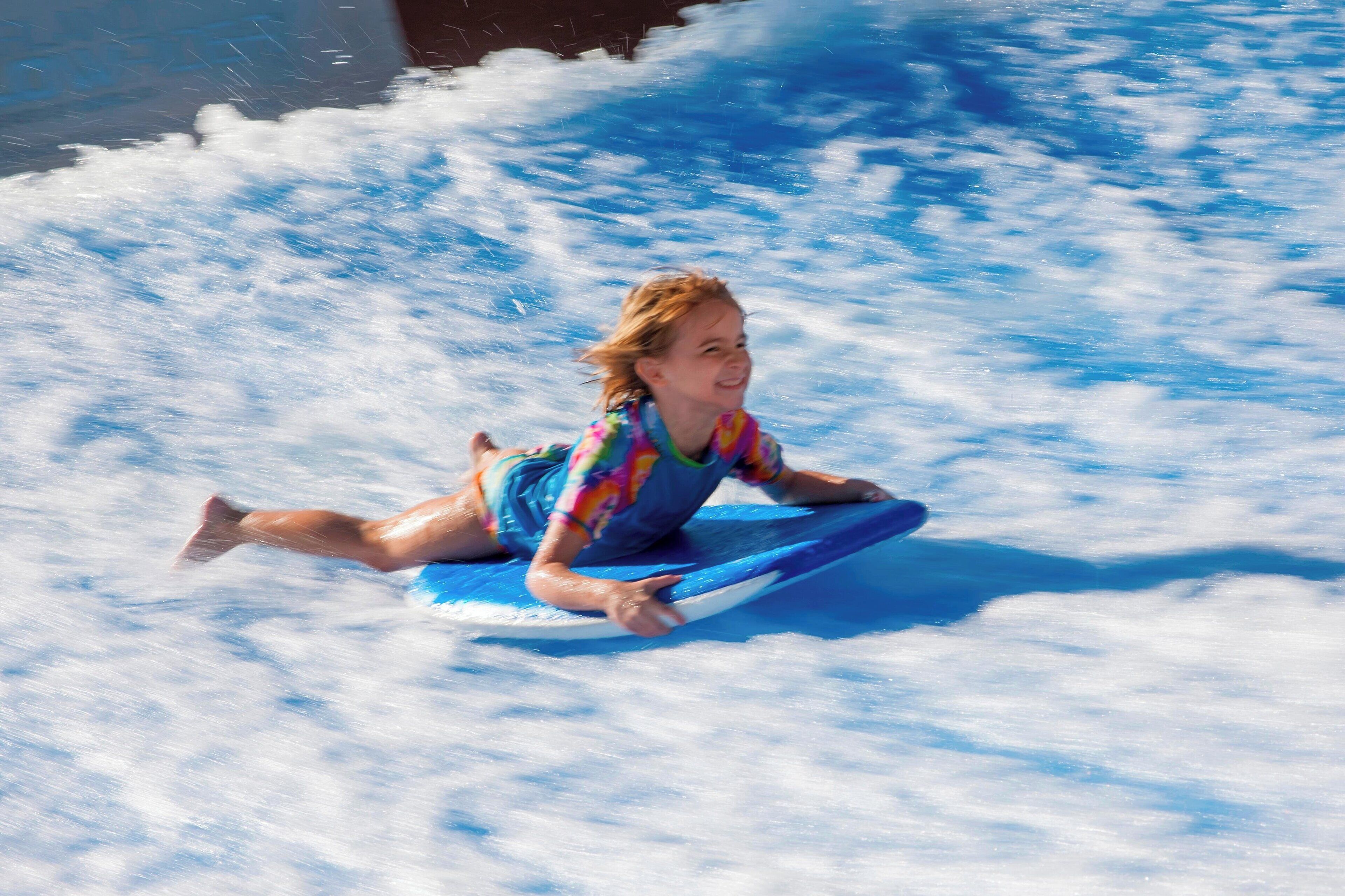 A person riding a blue water slide.