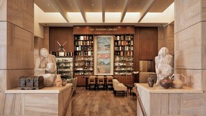 A library with wooden walls, a large painting, and shelves of books and decorative items. - The Westin Kierland Resort and Spa (Scottsdale)