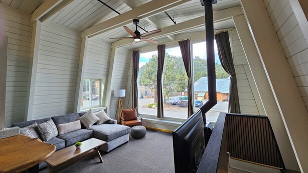 A cozy living room with a sectional sofa, a flat-screen TV, and a wooden coffee table. - Cinnamon Bear Inn (Mammoth Lakes)