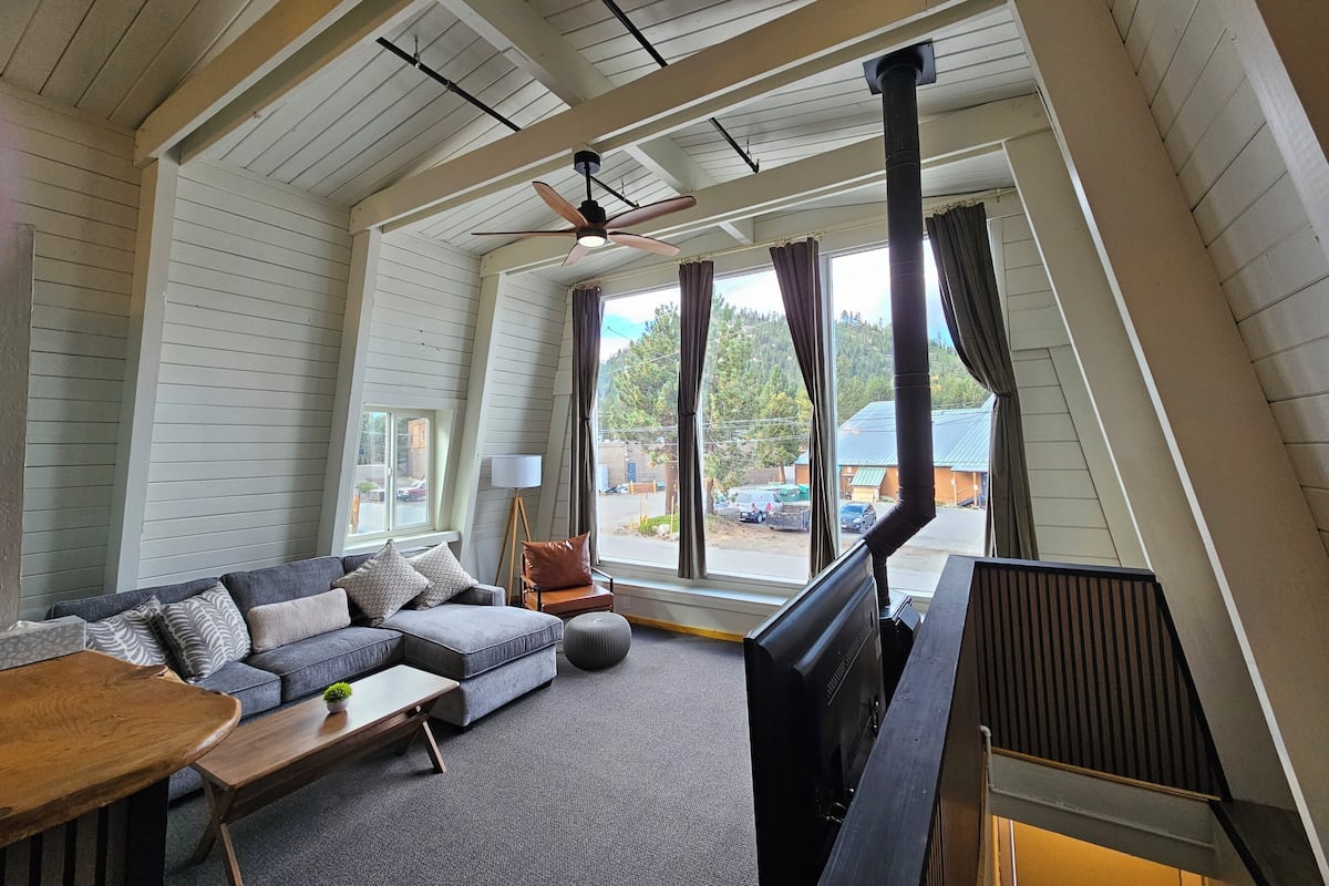 A cozy living room with a sectional sofa, a flat-screen TV, and a wooden coffee table.