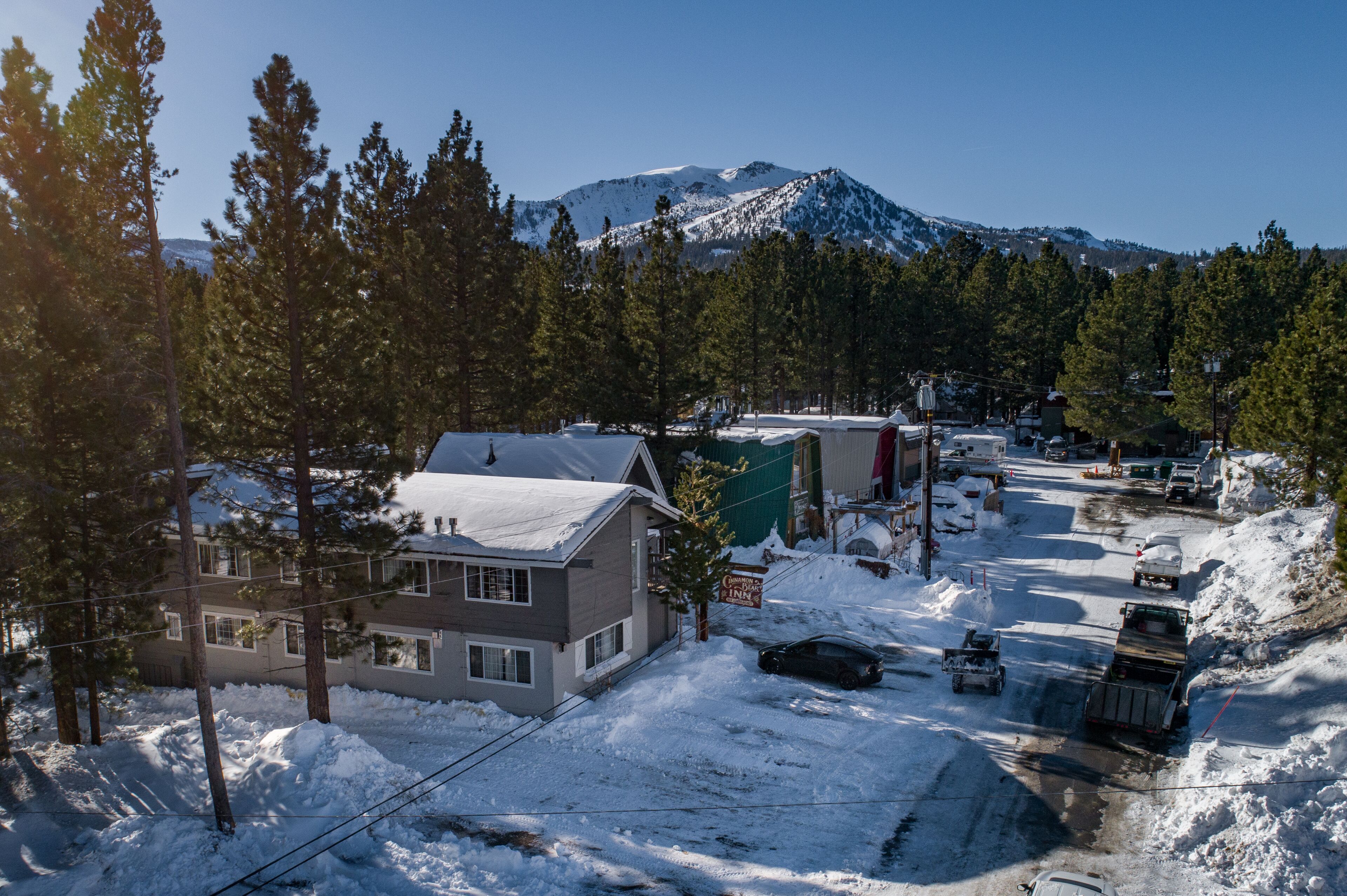 Une rue enneigée, avec un bâtiment portant l’inscription « Glen Inn » et une montagne en arrière-plan.