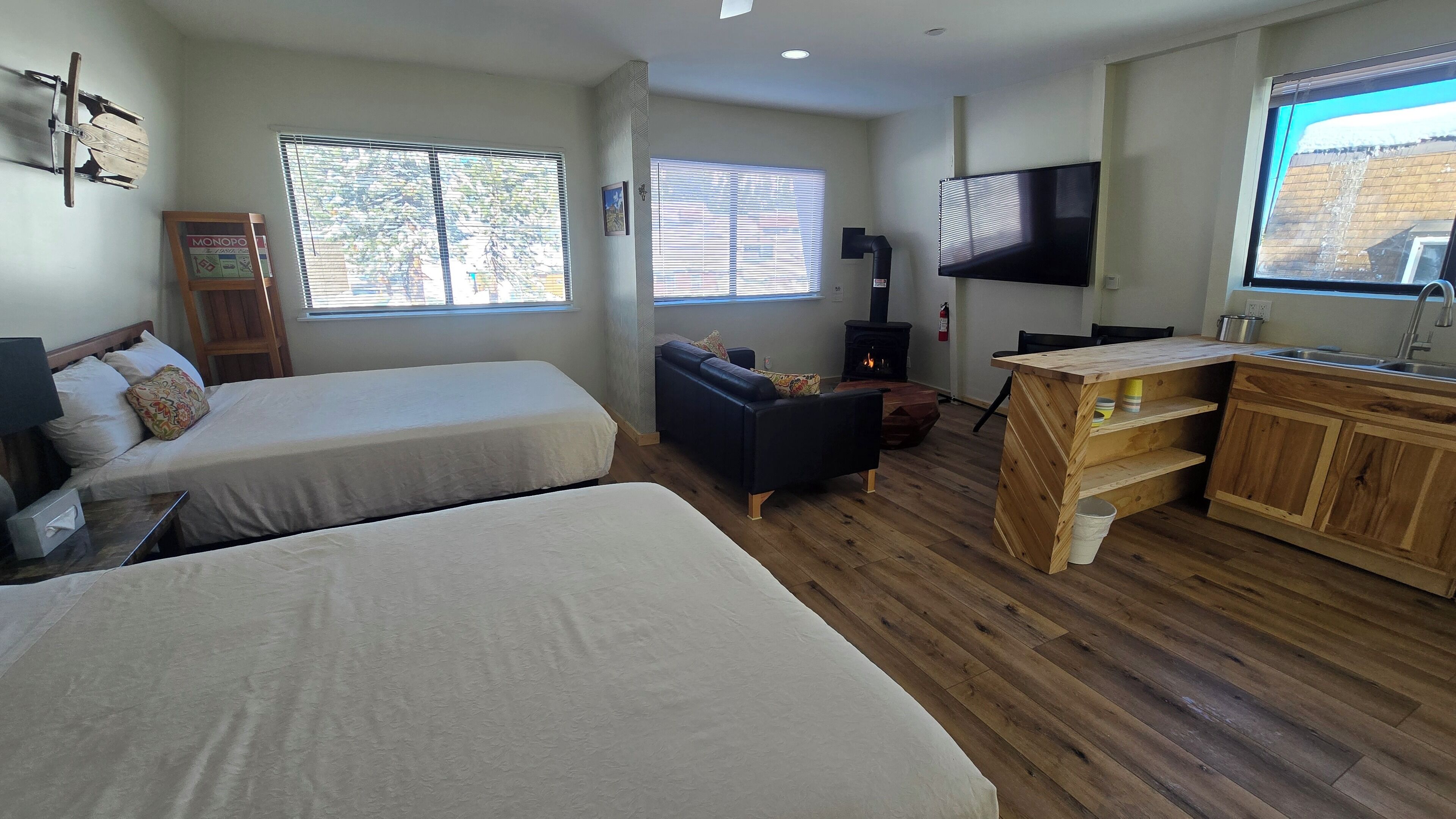 Una habitación con dos camas, un sofá, un televisor y un armario de madera.