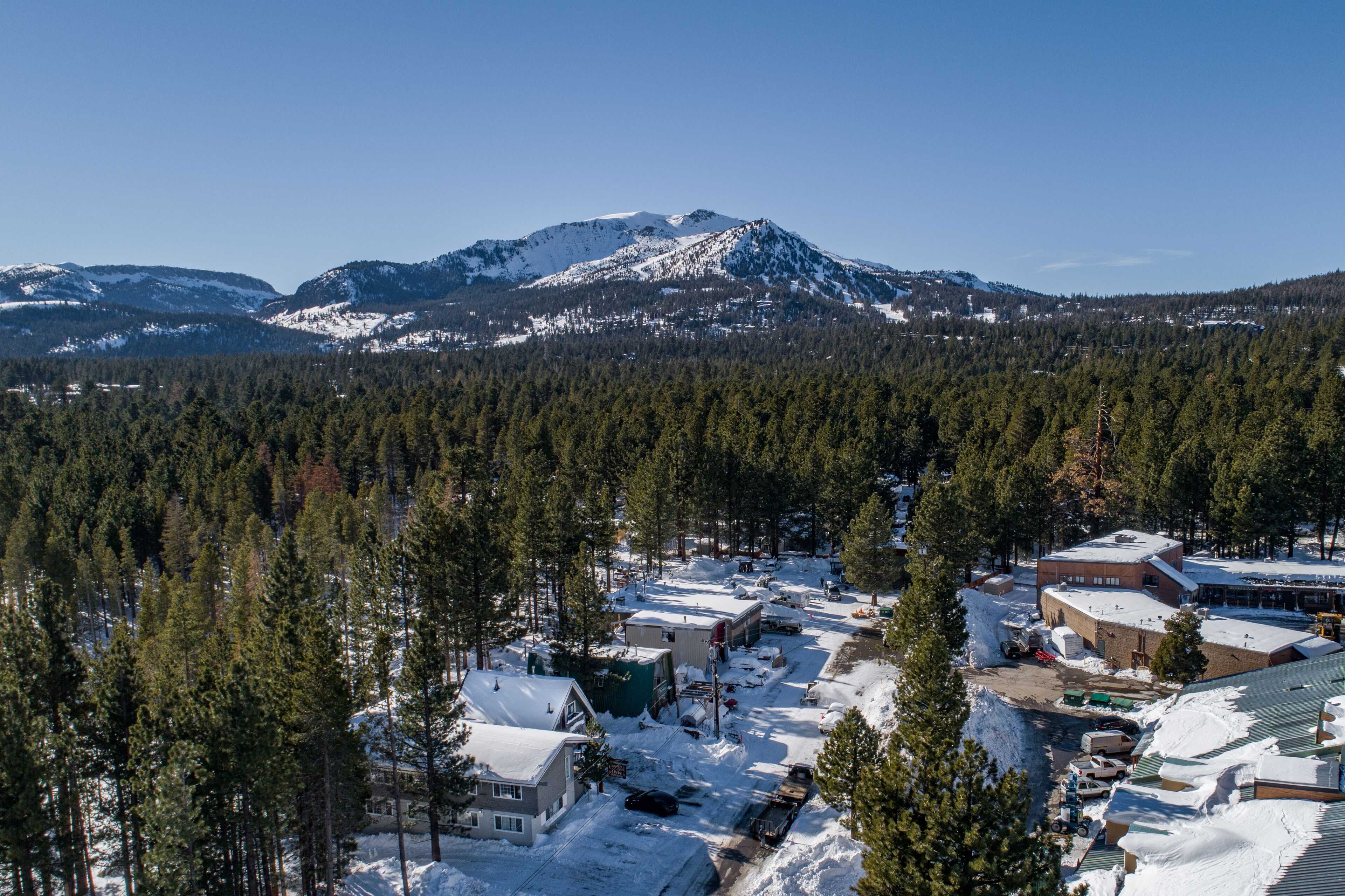 A snow-covered town with buildings and a mountain in the background.