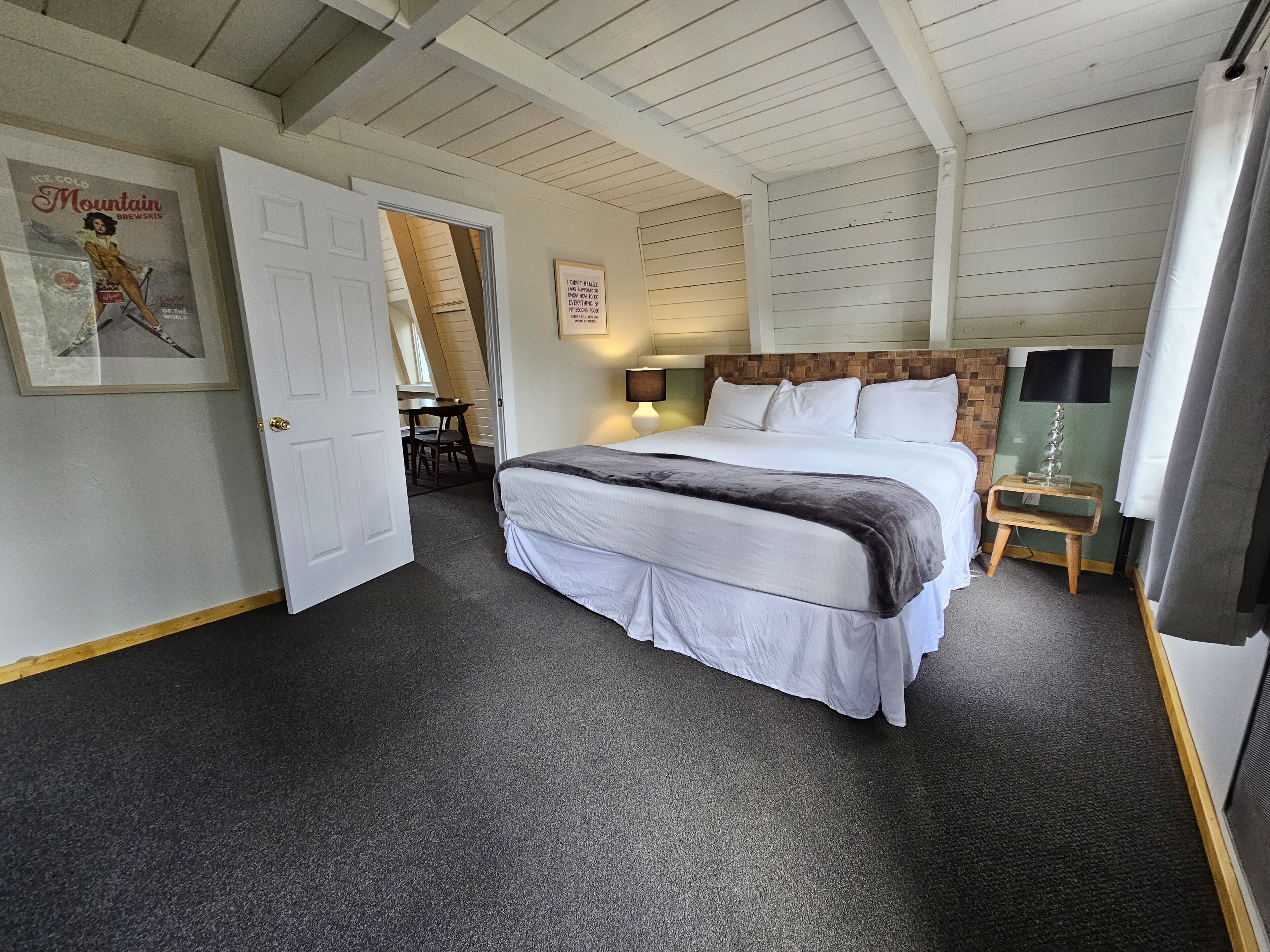 A bedroom with a bed, a desk, and a chair.