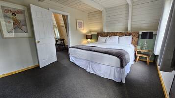 A bedroom with a bed, a desk, and a chair.