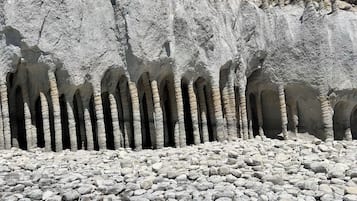 A rocky landscape with a series of natural arches and a clear sky.