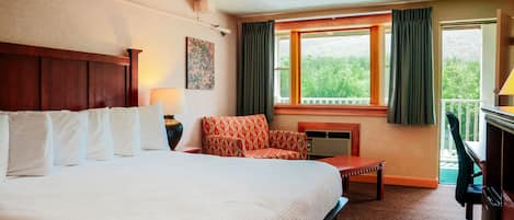 Habitación de hotel con una cama grande, una silla, un escritorio y una ventana con cortinas.