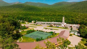 A hotel with a tennis court, parking area, and a tower structure. - Indian Head Resort (Lincoln)