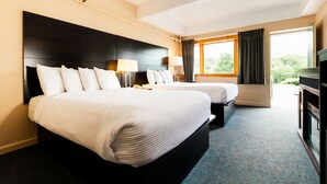 A hotel room with two beds, a large window, a flat-screen TV, and a desk. - Indian Head Resort (Lincoln)