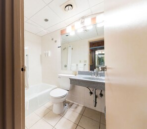 A bathroom with a bathtub, toilet, and sink. - Indian Head Resort (Lincoln)
