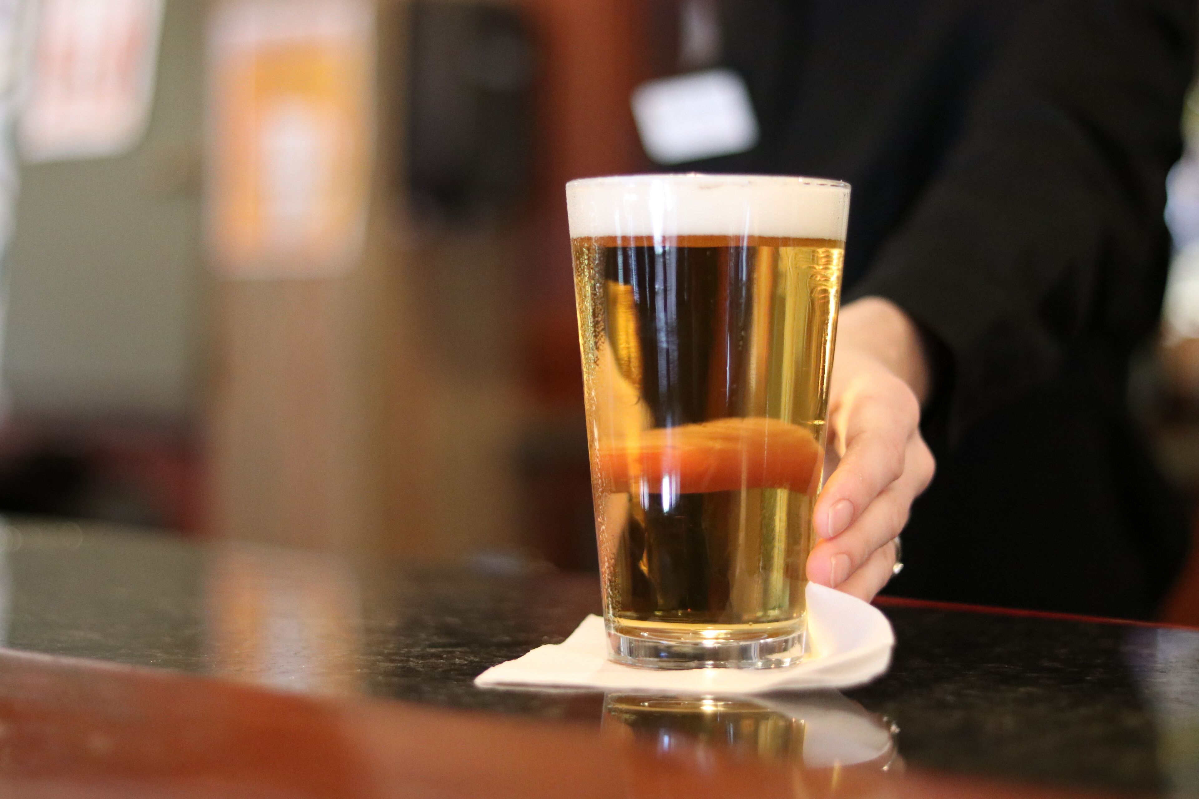 Een glas bier op een onderzetter in een bar.