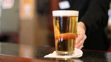A glass of beer on a coaster at a bar.
