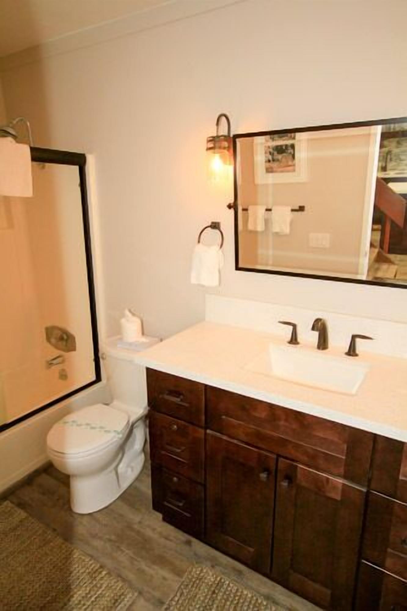 Ein Badezimmer mit Toilette, Waschtisch mit Spiegel und Waschbecken.