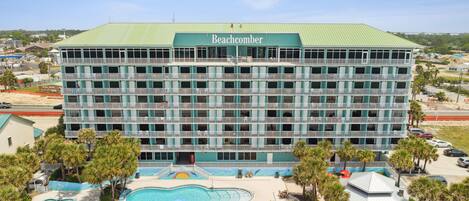 A large hotel with a green roof and multiple balconies.