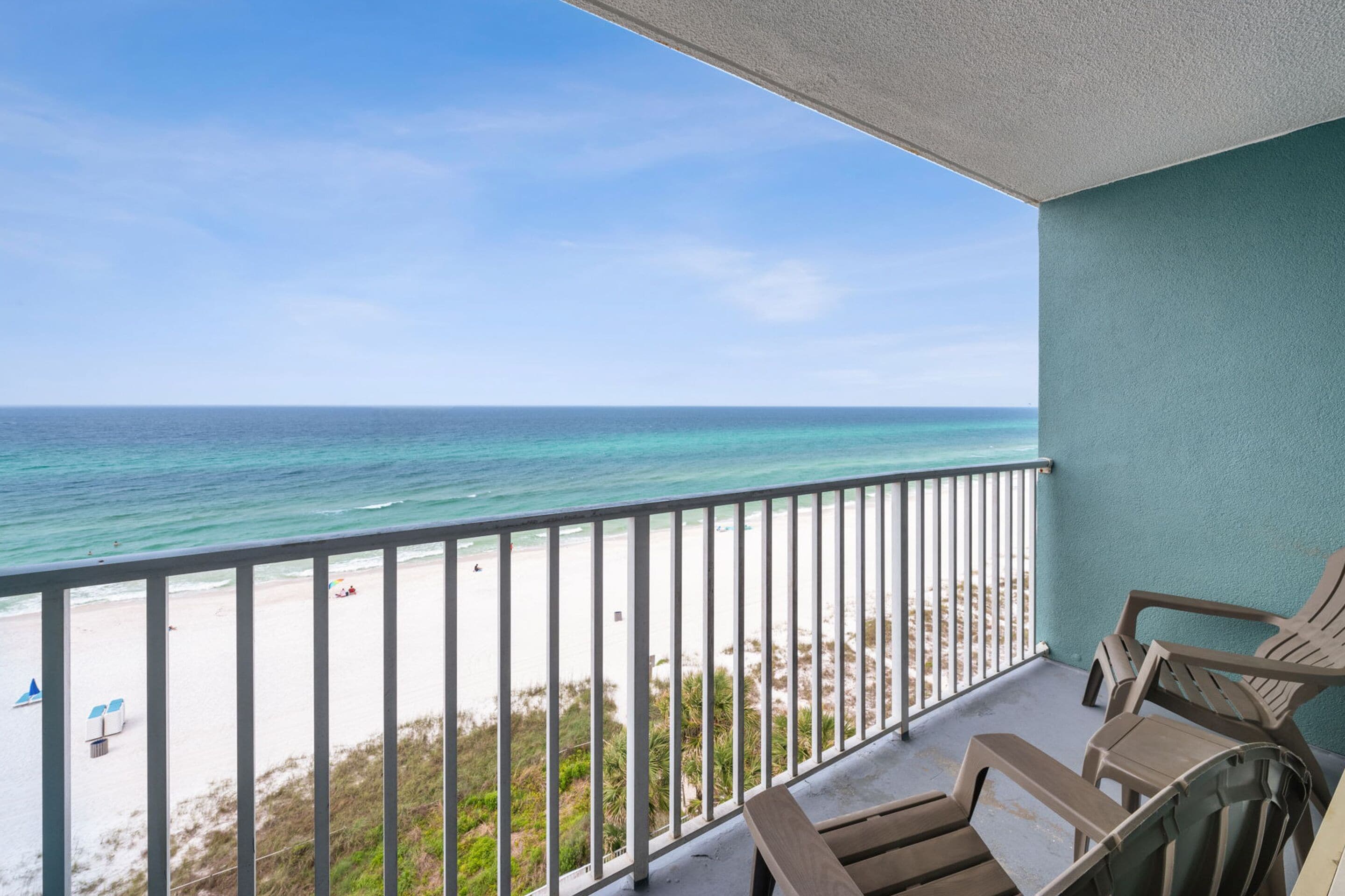 A balcony with a view of the beach and ocean.