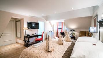 Ein Hotelzimmer mit Bett, Schreibtisch, Fernseher und Stuhl.