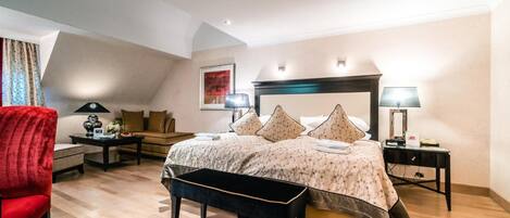 Un dormitorio con una cama, una silla roja, un escritorio y una lámpara.