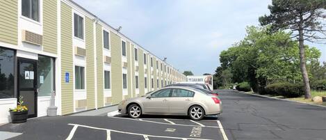 A row of single-story buildings with a parking lot in front.
