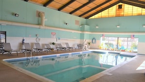Una piscina interior amb gandules, un senyal de socorrista i banderes americanes.