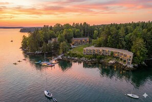 A lakeside lodge with multiple buildings, docked boats, and a forested shoreline. - Ocean Gate Inn (Southport)