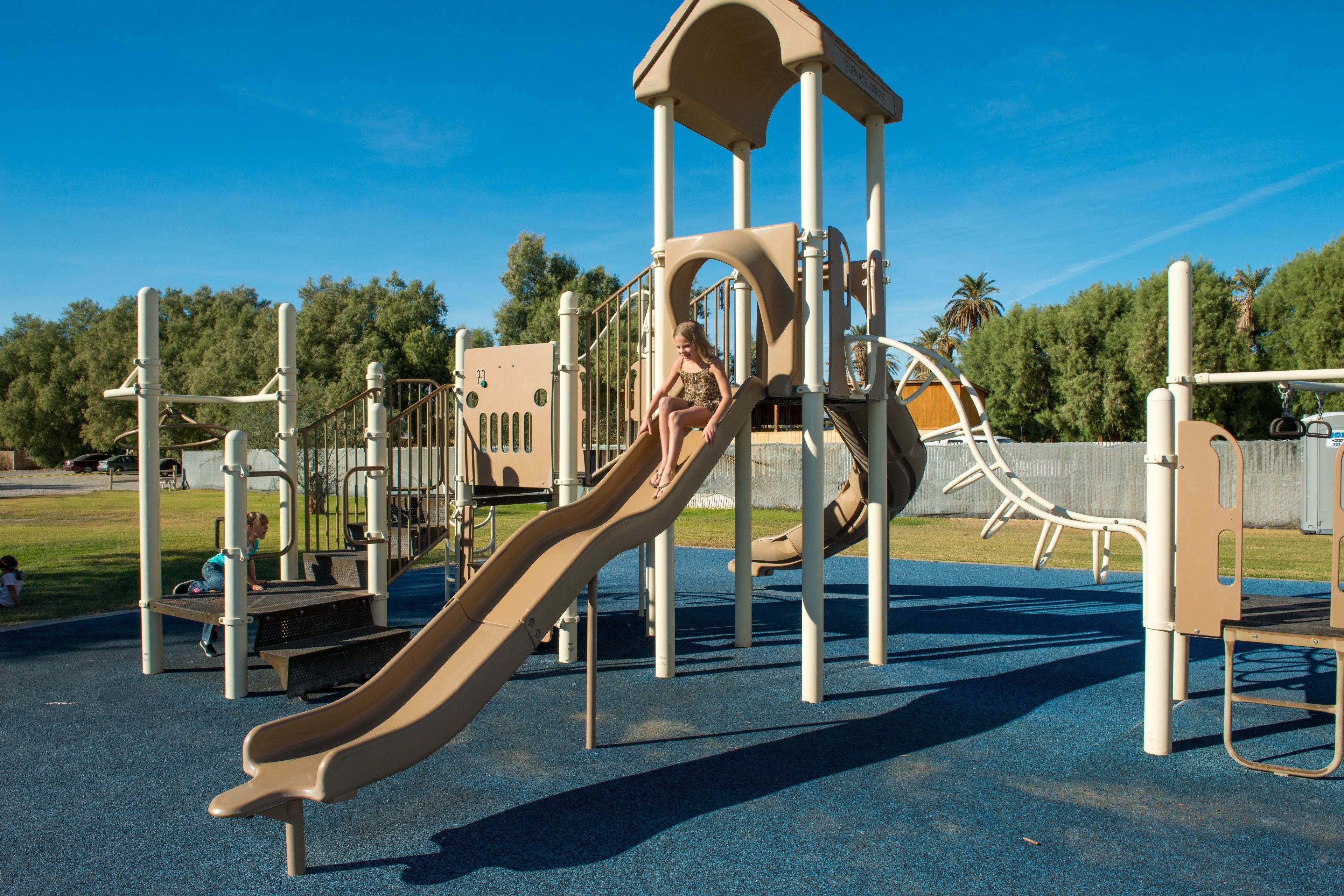 A playground with a slide and climbing structures.