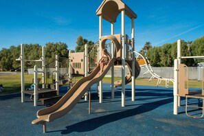 A playground with a slide and climbing structures.