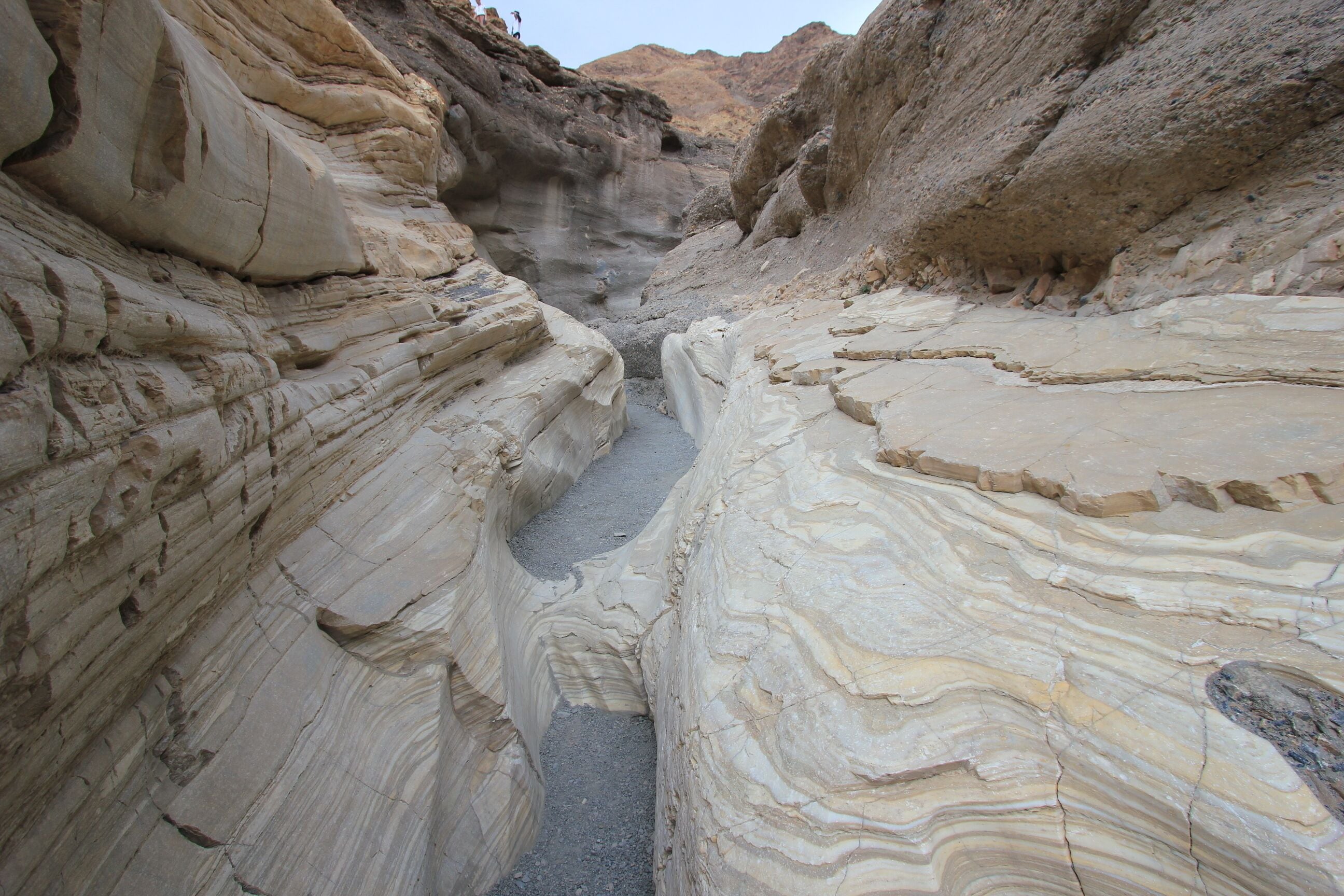 A narrow canyon with layered rock formations.